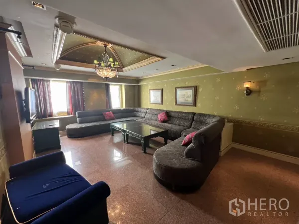 พื้นที่ขายปลีก ให้เช่าในWatthana, Bangkok - ห้องนั่งเล่นมีโคมระย้า ผนังสีเขียว และโซฟาแอลสีเทา