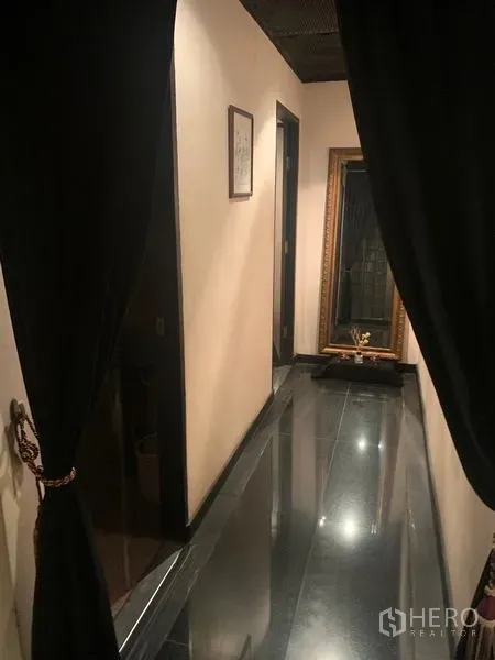 Retail Space for rent in Bang Rak, Bangkok - Narrow hallway with black tile floor, cream walls, draped curtains and a large mirror.
