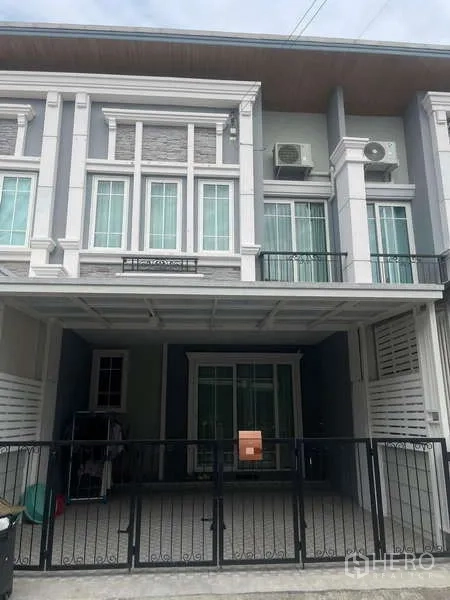 ทาวน์เฮาส์ ให้เช่าหรือขาย - หน้าบ้านทาวน์เฮาส์สองชั้นสไตล์โมเดิร์น พร้อมโรงจอดรถมีหลังคาและรั้ว