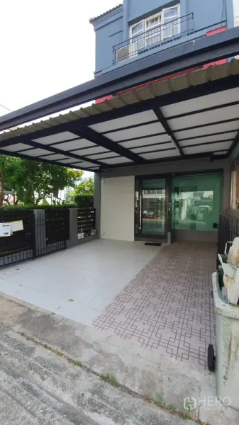 带办公室的家 出租在Lat Phrao, Bangkok - 前院带顶车棚，铺砖车道与玻璃入户门。