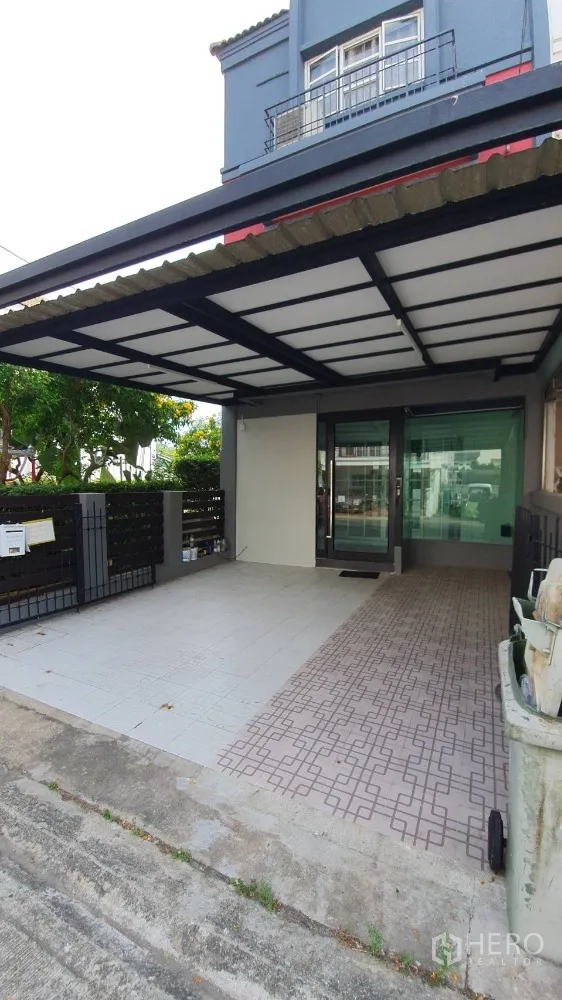 带办公室的家 出租在Lat Phrao, Bangkok - 前院带顶车棚，铺砖车道与玻璃入户门。