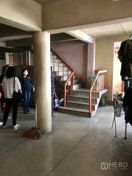 Shophouse for rent in Khlong Toei, Bangkok - Ground floor area with concrete columns and a central staircase to upper levels.