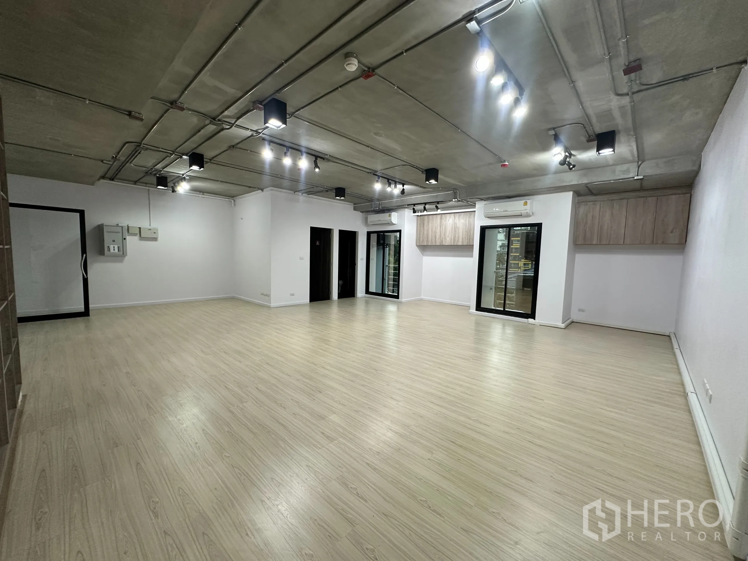 办公空间 出租在Watthana, Bangkok - 空置办公室，工业风天花，多组射灯与玻璃隔断。