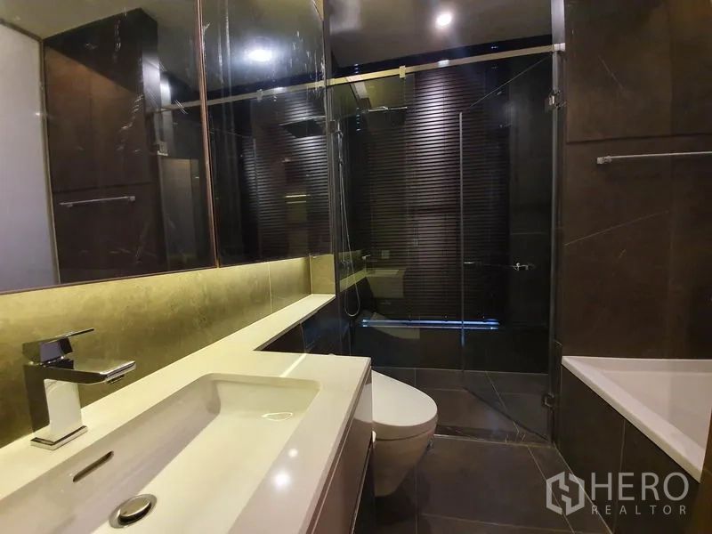 คอนโด ให้เช่าในHuai Khwang, Bangkok - ห้องน้ำสมัยใหม่ อ่างล้างหน้า กระจกบานใหญ่ ฝักบัวกระจก อ่างอาบน้ำ และกระเบื้องโทนเข้ม