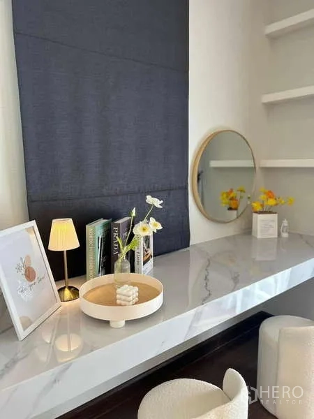 Detached House for rent in Bang Phli, Samut Prakan - Compact work or vanity desk with round mirror, books and decorative pieces.
