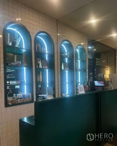 零售空间 出租在Watthana, Bangkok - 接待台与拱形灯槽展示柜，白色瓷砖墙面