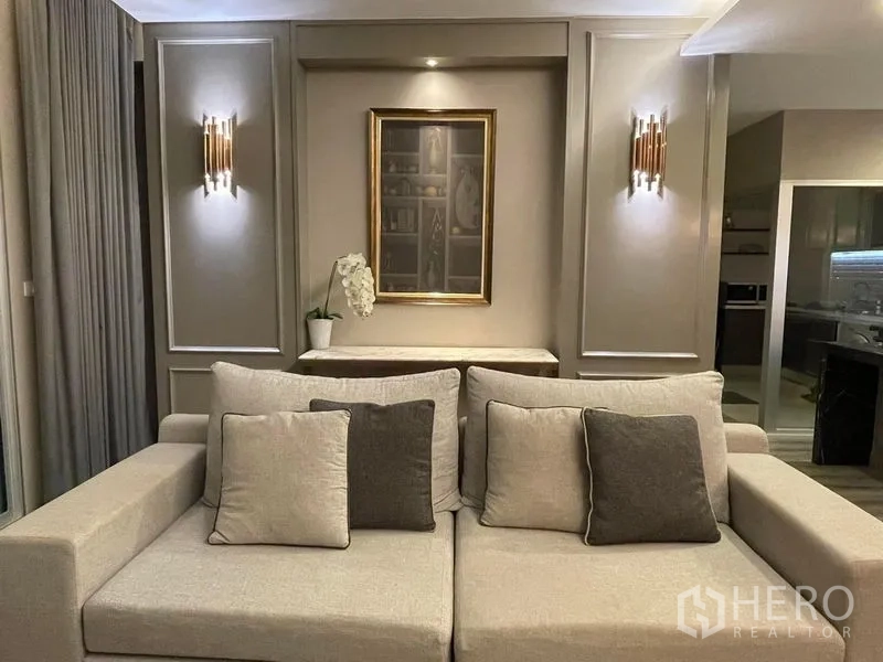 Condominium for sale in Sathon, Bangkok - Neutral-toned sofa seating area with wall sconces and framed artwork for an elegant feel.