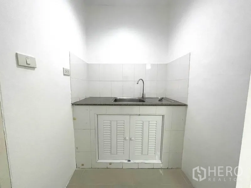 办公空间 出租在Khlong Toei, Bangkok - 紧凑小厨房，带台面、水槽与储物柜。
