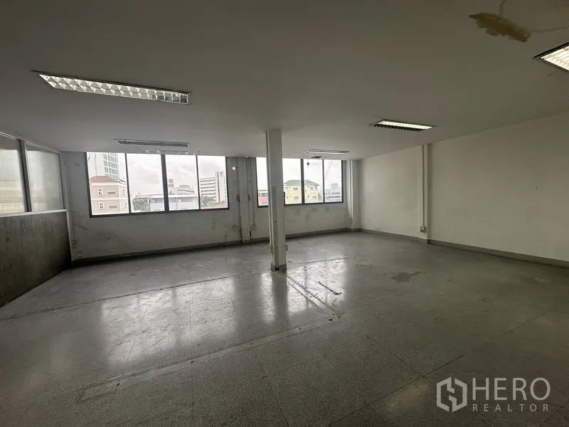 办公空间 出租在Khlong Toei, Bangkok - 转角办公室，多扇窗与中央立柱，简约装饰