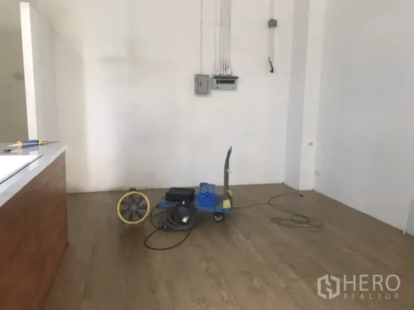 Retail Space for rent in Khlong Toei, Bangkok - Open 30 sqm shop space with wood flooring, high ceiling, white walls and surface-mounted power conduits.