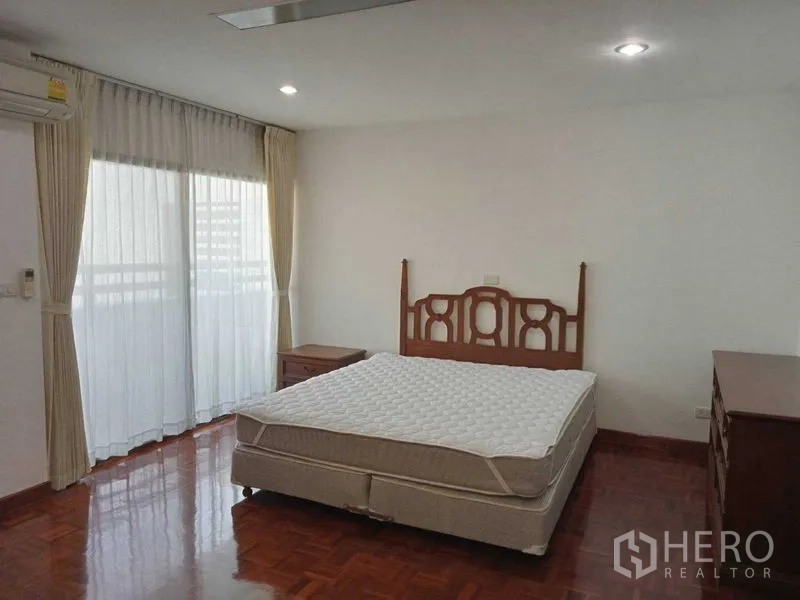 คอนโด ให้เช่าในWatthana, Bangkok - ห้องนอนสว่าง เตียงคู่ โต๊ะข้าง และประตูกระจกสูงพร้อมผ้าม่าน