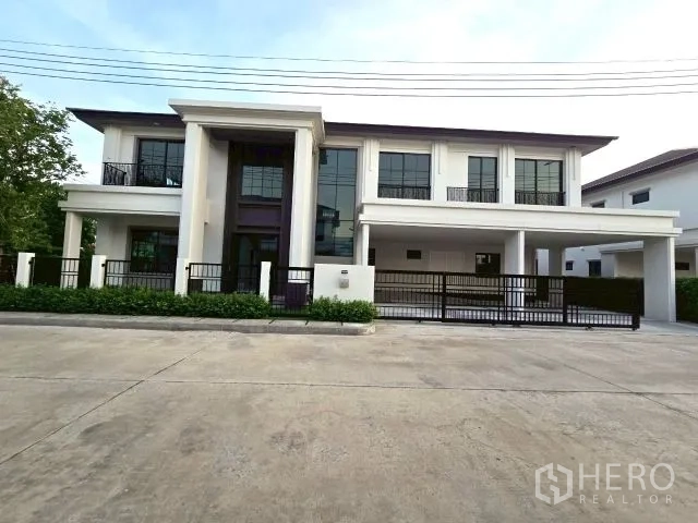 บ้าน ให้เช่าในBang Phli, Samut Prakan - ด้านหน้าบ้านเดี่ยวสองชั้นพร้อมรั้วและที่จอดรถในโครงการ