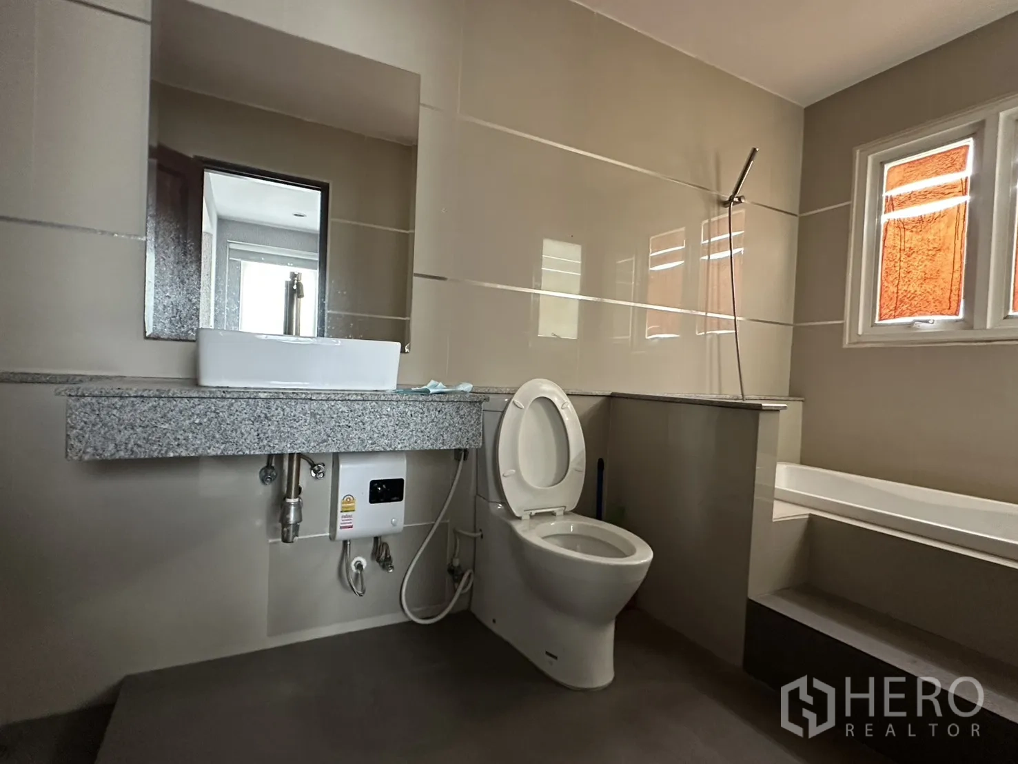 โฮมออฟฟิศ for rent in Watthana, Bangkok - ห้องน้ำพร้อมเคาน์เตอร์หินแกรนิต โถสุขภัณฑ์ และอ่างอาบน้ำยกสเต็ปใต้หน้าต่าง
