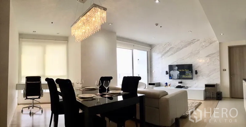 公寓 出租或出售在Watthana, Bangkok - 开放式客餐厅，水晶吊灯、窗边书桌与电视一应俱全。