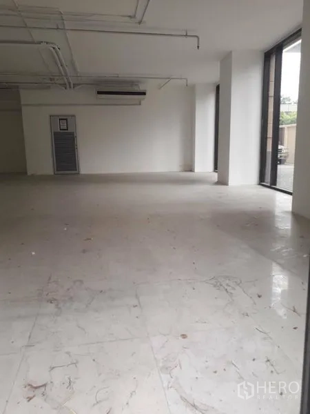 Retail Space for rent in Watthana, Bangkok - Retail unit with marble-look tiles, side windows, and exposed ceiling with air-conditioning.
