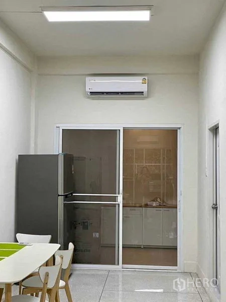 带办公室的家 出租或出售在Watthana, Bangkok - 紧凑餐区与简易厨房，配冰箱、推拉玻璃门与壁挂空调。