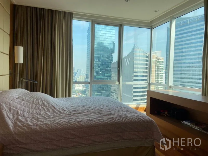Condominium for rent in Sathon, Bangkok - Corner master bedroom with wraparound floor-to-ceiling windows and Bangkok skyline views.