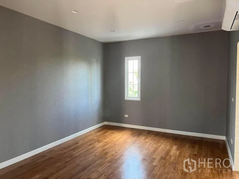 Detached House for sale in Yan Nawa, Bangkok - Empty bedroom with grey walls, wood floors and a narrow window.