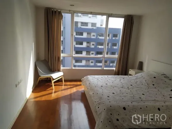 公寓 出售在Khlong Toei, Bangkok - 大卧室设落地窗，城市景观与休闲椅