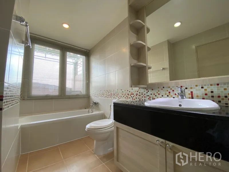 Condominium for rent in Bang Rak, Bangkok - Bright bathroom with bathtub, mosaic tile backsplash, vanity and large window.