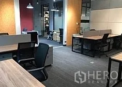 办公空间 出租在Khlong Toei, Bangkok - 开放式办公室，灰色地毯、玻璃隔断与顶置照明及移动柜。