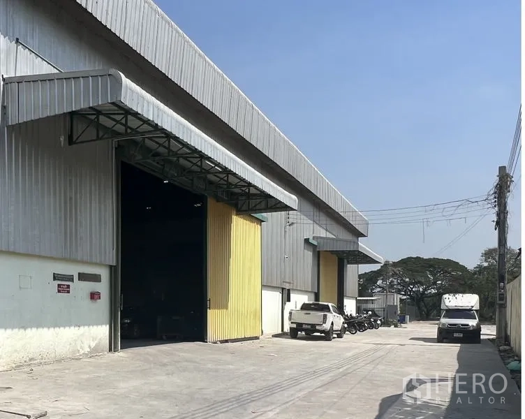 货栈 出租在Lat Krabang, Bangkok - 仓库前的宽阔混凝土通道，敞开的装卸门，适合卡车停靠。