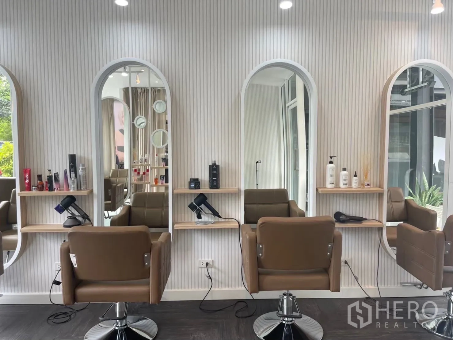 Retail Space for rent in Khlong Toei, Bangkok - Three salon stations with arched mirrors, shelving and brown chairs.