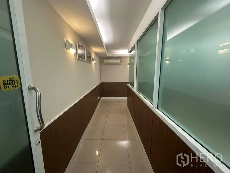 Office Space for sale - Long corridor with frosted glass panels and a push door handle.