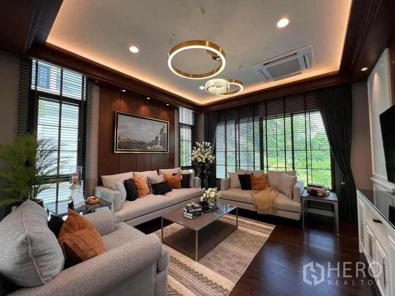 Detached House for sale in Yan Nawa, Bangkok - Bright living room with large windows, modern sofas and ring pendant lights.