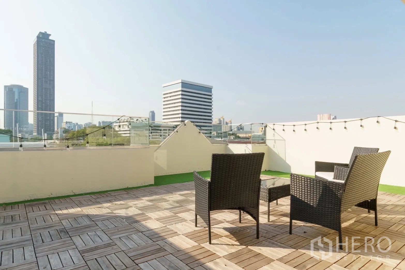 ทาวน์เฮาส์ for rent in Watthana, Bangkok - ดาดฟ้าพื้นไม้พร้อมชุดเก้าอี้หวาย มองเห็นวิวตึกเมืองกรุงเทพฯ