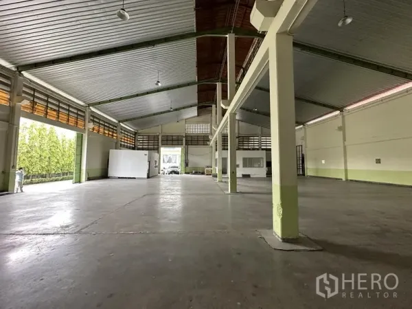 Warehouse for rent in Lat Krabang, Bangkok - Warehouse hall with large roller‑shutter openings and a covered loading area facing the driveway.