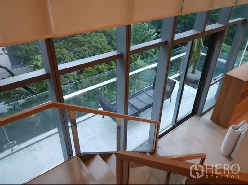 公寓 出租或出售在Watthana, Bangkok - 从楼梯望向沿玻璃立面的长阳台，设户外座椅与绿景