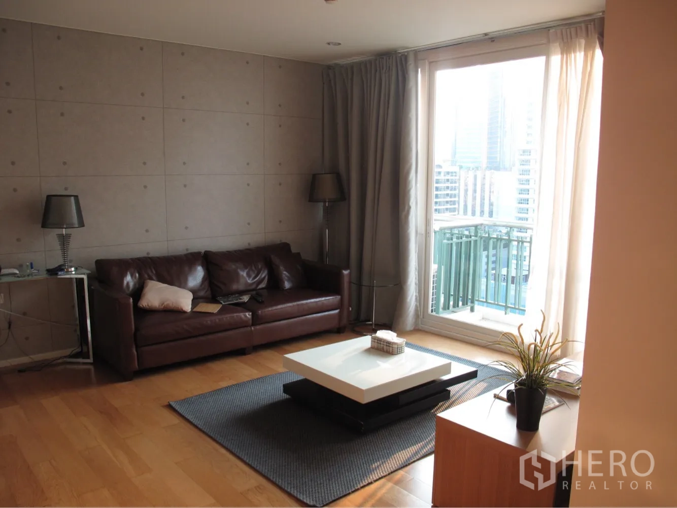 คอนโด ให้เช่าในWatthana, Bangkok - ห้องนั่งเล่นโซฟาหนัง ประตูระเบียงและพื้นไม้