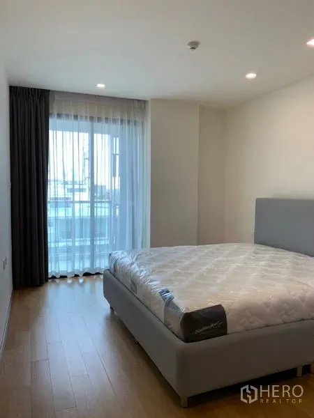 公寓 出售在Khlong Toei, Bangkok - 次卧配大窗与纱帘，浅色木地板温馨明亮。