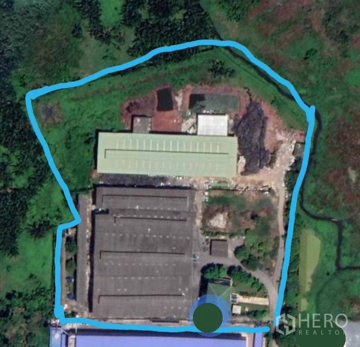 Warehouse for rent or sale in Mueang Samut Sakhon, Samut Sakhon - Aerial view of an industrial compound with two large warehouse roofs, internal roads, and the site boundary highlighted.