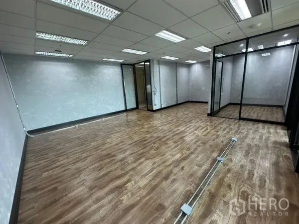 Office Space for rent in Chatuchak, Bangkok - Spacious office area with data cabling trunking, textured gray walls, and glass room dividers.