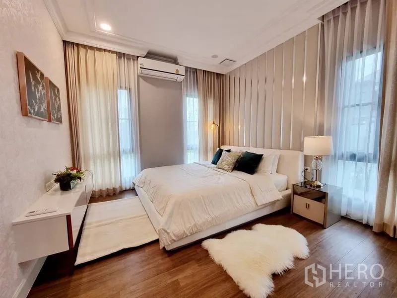 Detached House for rent in Saphan Sung, Bangkok - Guest bedroom with white bed, soft curtains, wood floor, and air conditioning.