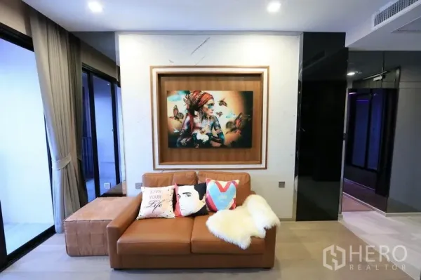 公寓 出租或出售在Watthana, Bangkok - 温馨小客厅，装饰画、阳台门与柔和灯光。