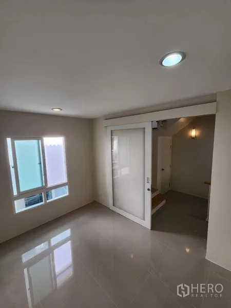 联排别墅 出租在Wang Thonglang, Bangkok - 楼层过厅，带推拉玻璃隔断与采光窗。