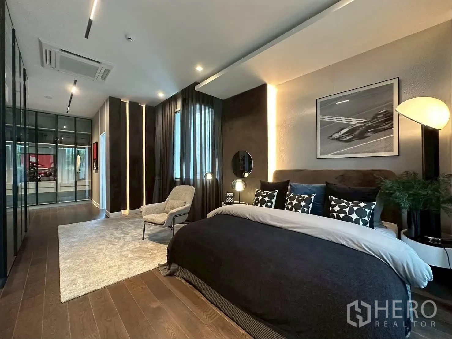 独栋房屋 for rent or sale in Suan Luang, Bangkok - 宽敞卧室带休闲椅、通顶衣柜、木地板与隐藏灯带。