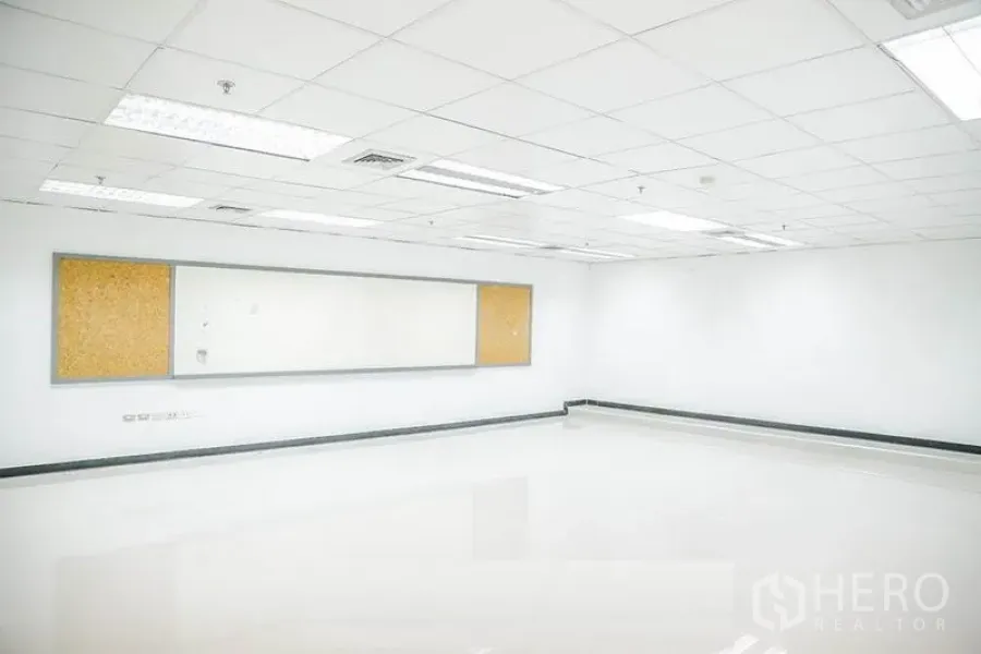 办公空间 出租在Bang Na, Bangkok - 明亮的开放式办公室，白色地砖、吊顶、长白板与软木公告板。