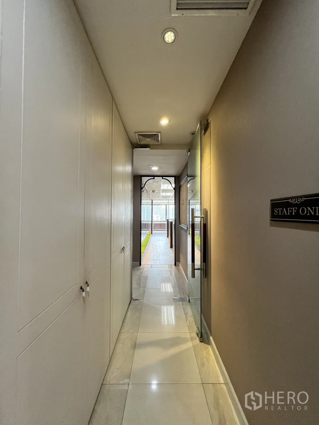 Office Space for rent in Watthana, Bangkok - Staff corridor with storage cabinets leading to a bright outdoor area.