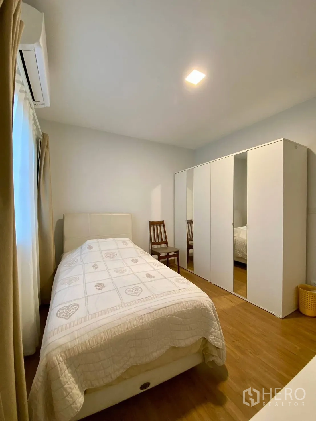 Semi-detached House for rent in Bang Phli, Samut Prakan - Cozy bedroom with single bed, large white wardrobe and wood floors.