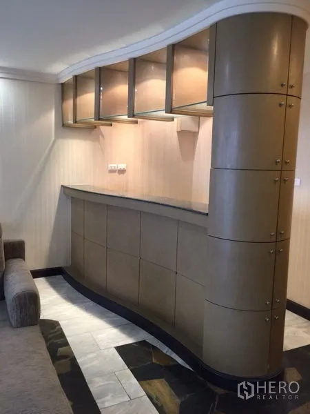 Condominium for rent in Watthana, Bangkok - Curved built-in bar counter with overhead cabinets beside the living area.