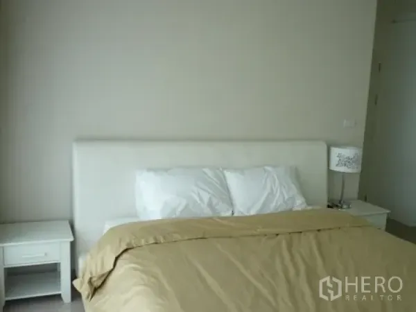 Condominium for rent in Watthana, Bangkok - Bright master bedroom with a white headboard, bedside tables, and beige bedding.