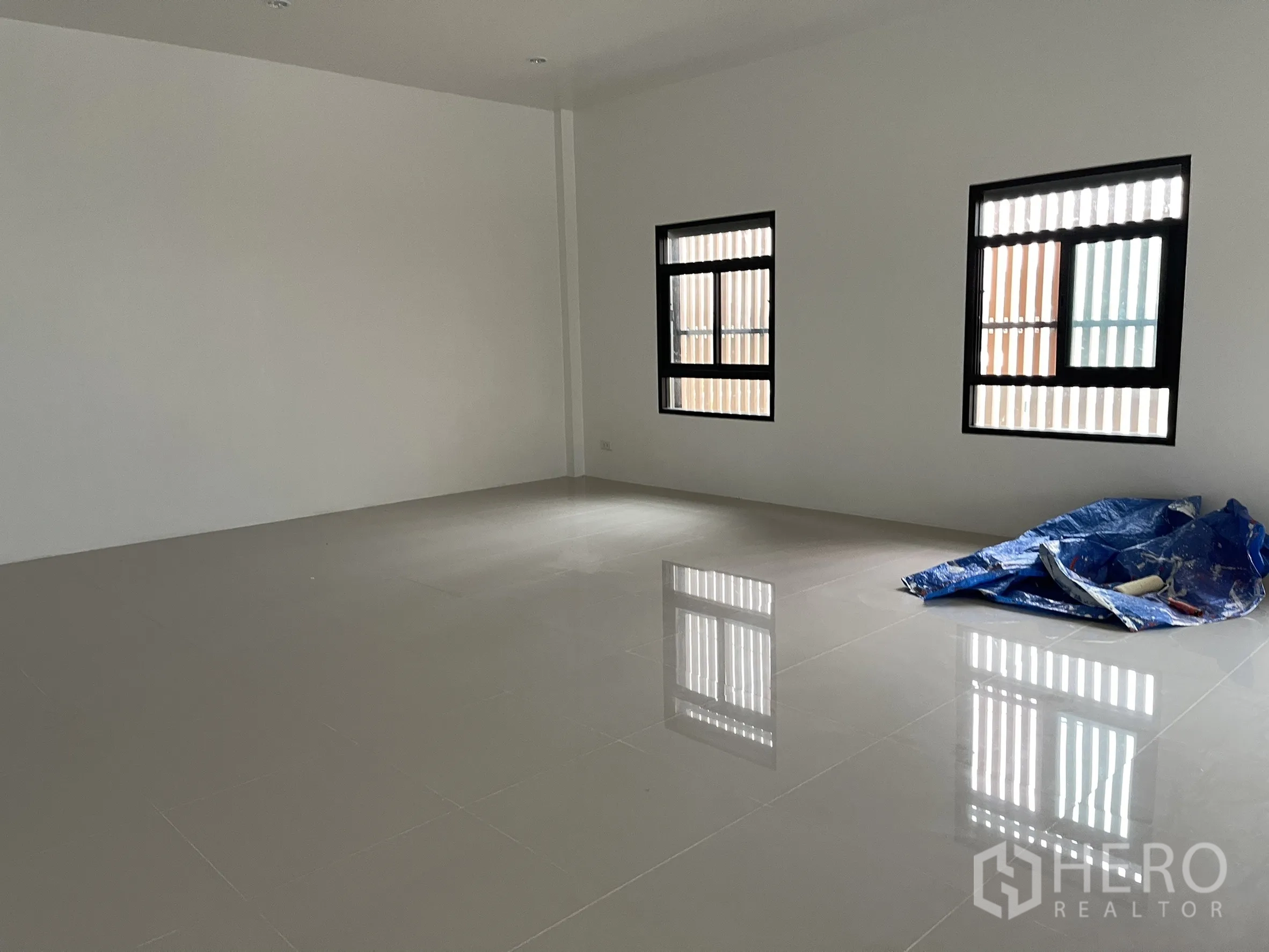 Factory for rent or sale in Lam Luk Ka, Pathum Thani - Large open-plan office area with polished tiles and twin windows.