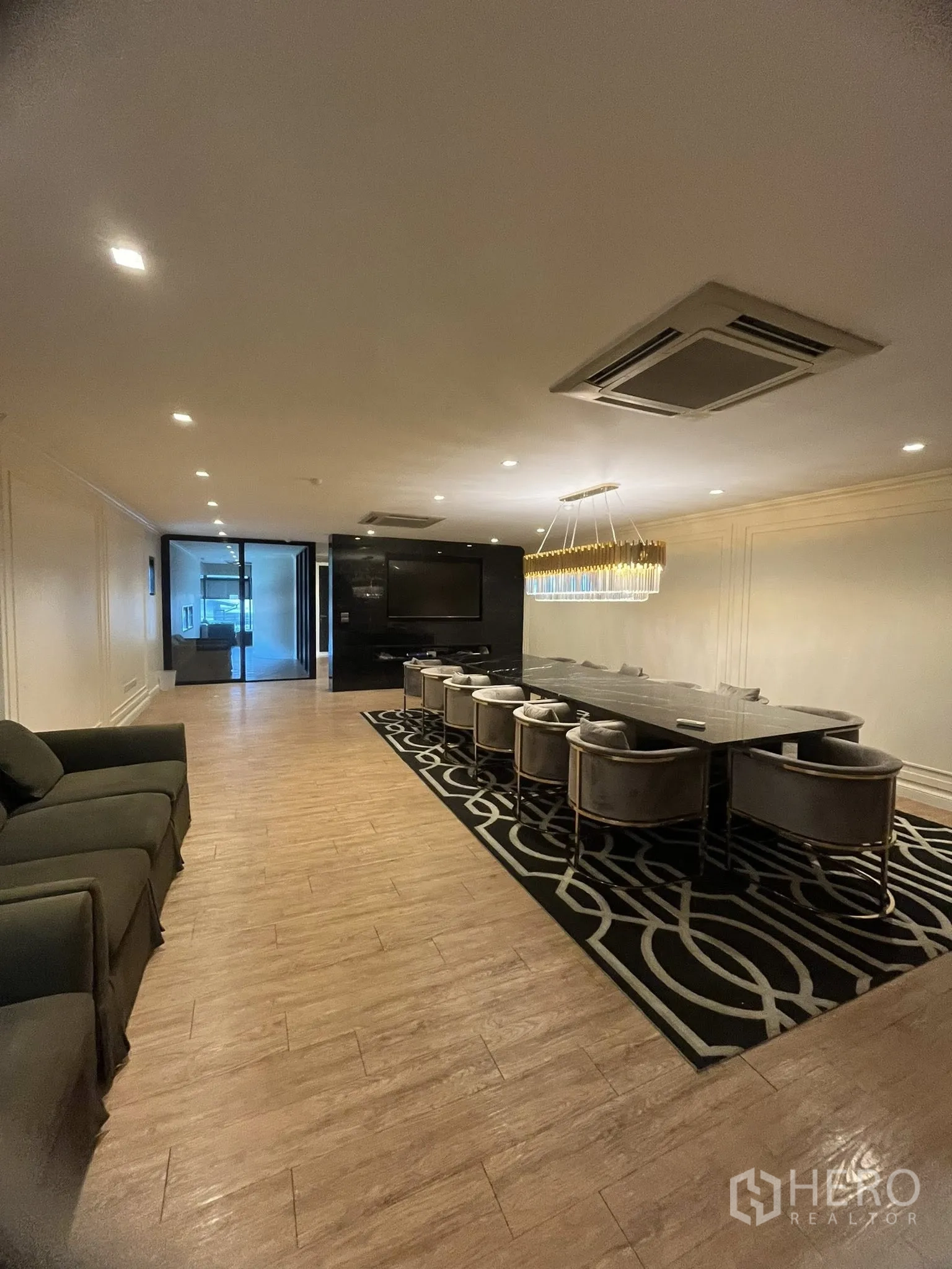 家庭办公室 for rent in Watthana, Bangkok - 正式会议/餐叙空间，长桌、水晶吊灯与沙发座。