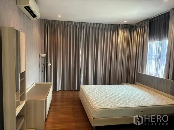 独立式住宅 出租在Bang Phli, Samut Prakan - 主卧木地板，大床、厚窗帘与空调