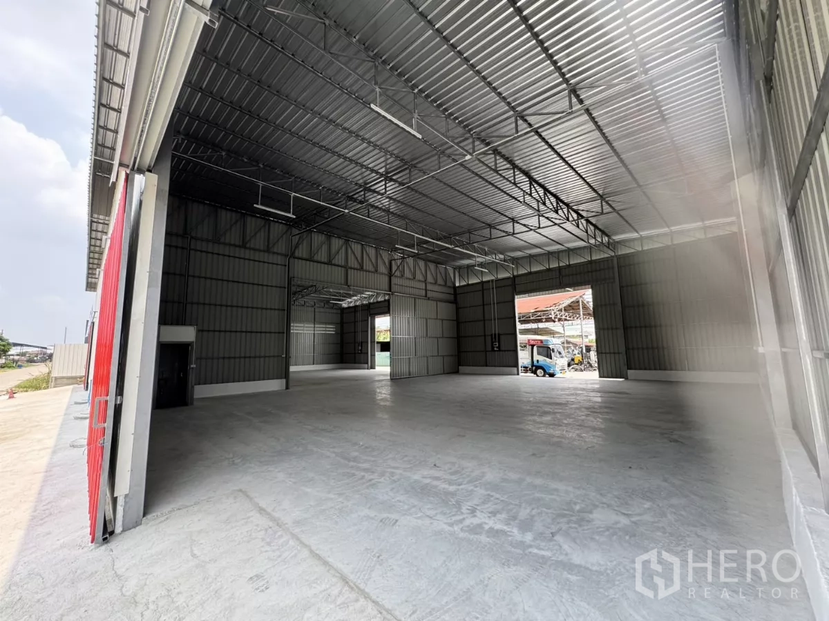 Warehouse for rent in Lam Luk Ka, Pathum Thani - View from the loading apron into the warehouse showing wide-span structure and multiple door bays.