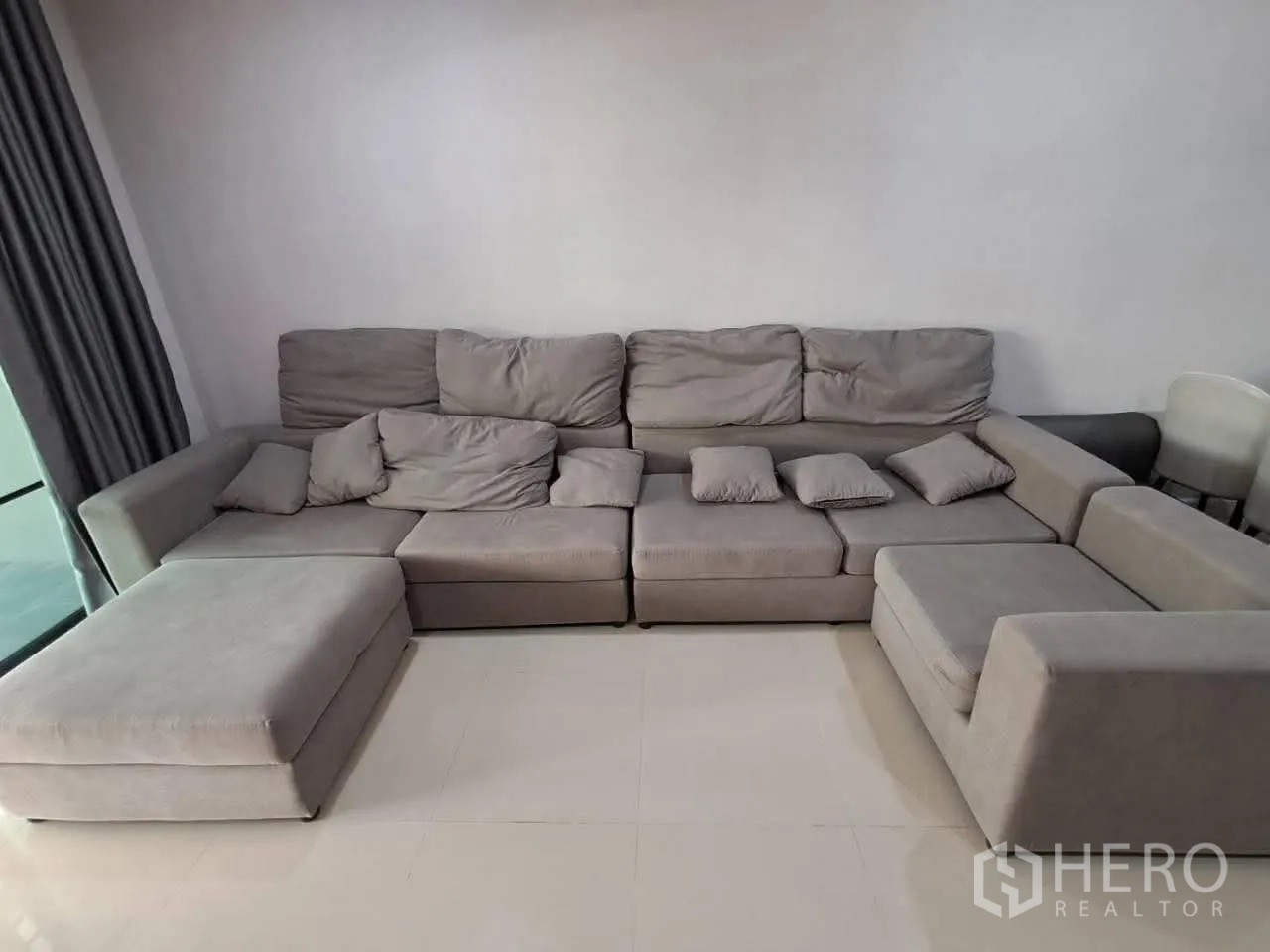 Townhouse for rent in Bang Kapi, Bangkok - Large L-shaped gray sectional sofa in the living room.